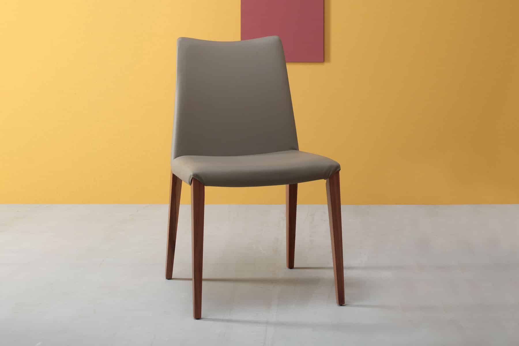 Sedia in legno massello di frassino e rivestimento in ecopelle, velluto o pelle. Schienale basso. Design e produzione made in Italy. Consegna a domicilio.