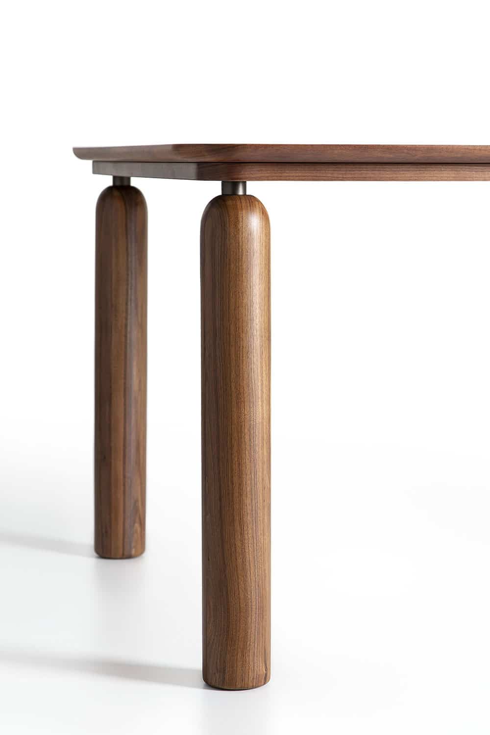 Dettaglio delle gambe rotonde in noce canaletto del tavolo GO