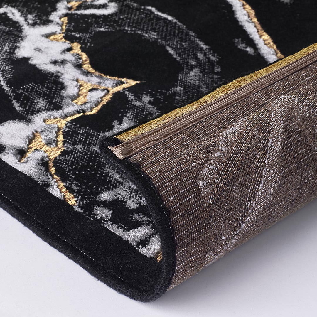 Gros plan sur le motif marbré noir et clair du tapis Gabrielle