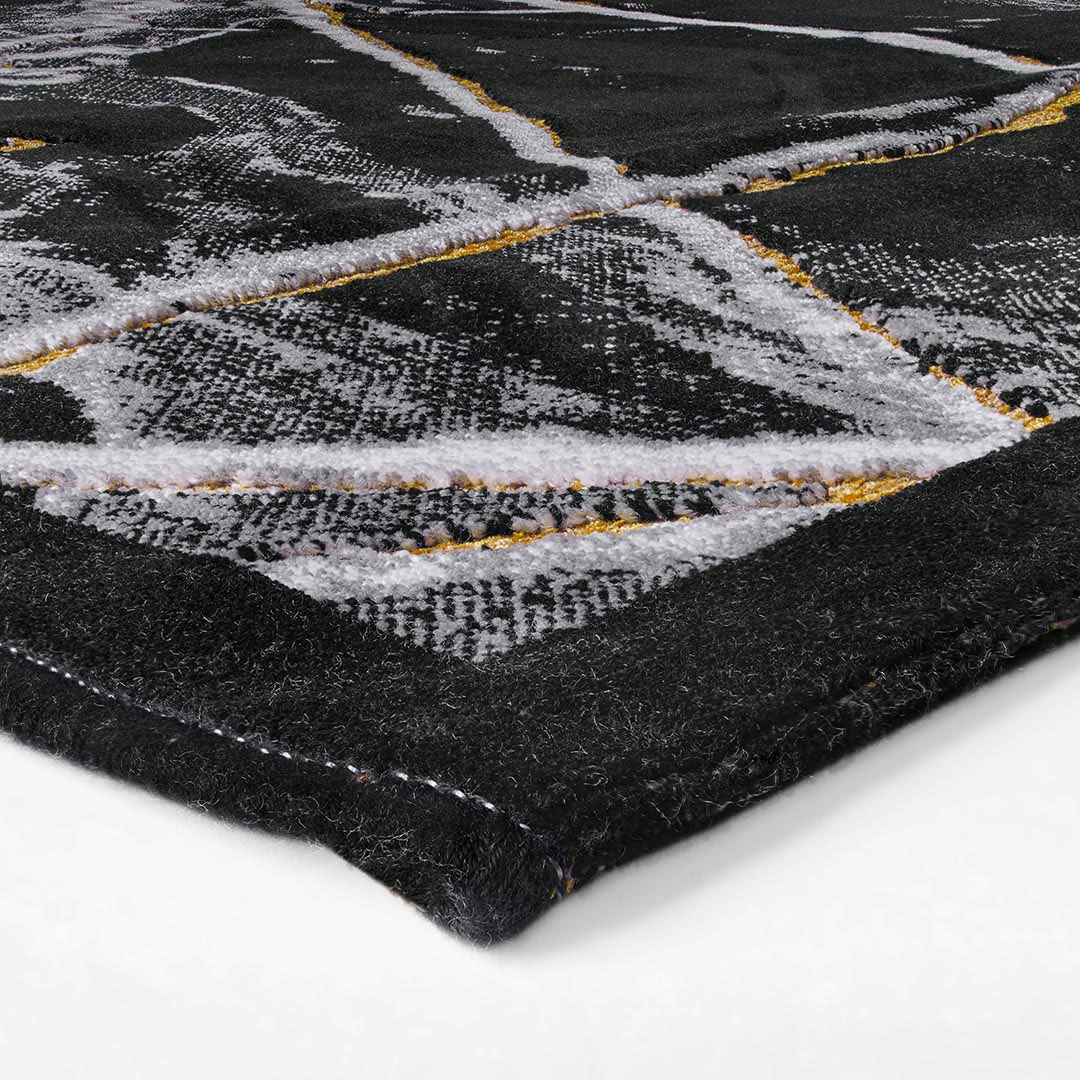 Gros plan sur le motif marbré noir et clair du tapis Gabrielle