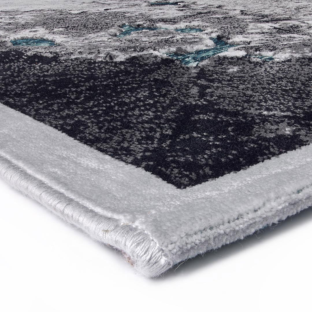 Gros plan sur les reflets turquoise du tapis Gabrielle