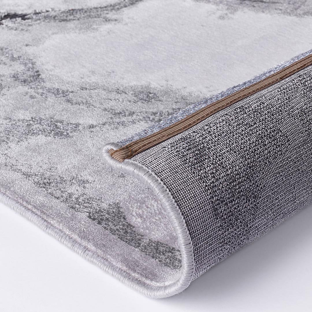 Gros plan sur les veines marbrées grises du tapis Gabrielle