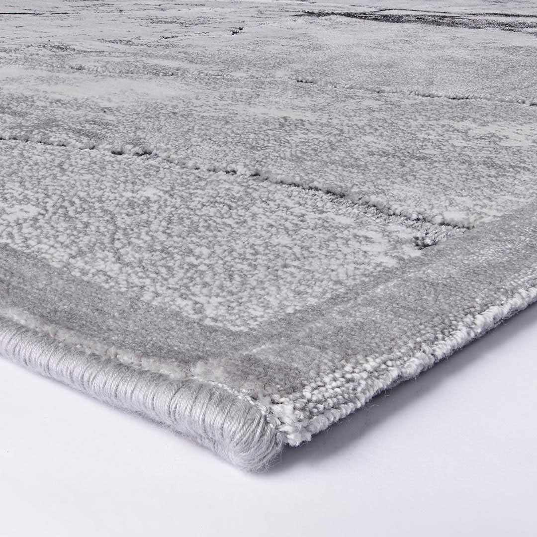 Gros plan sur les veines marbrées grises du tapis Gabrielle
