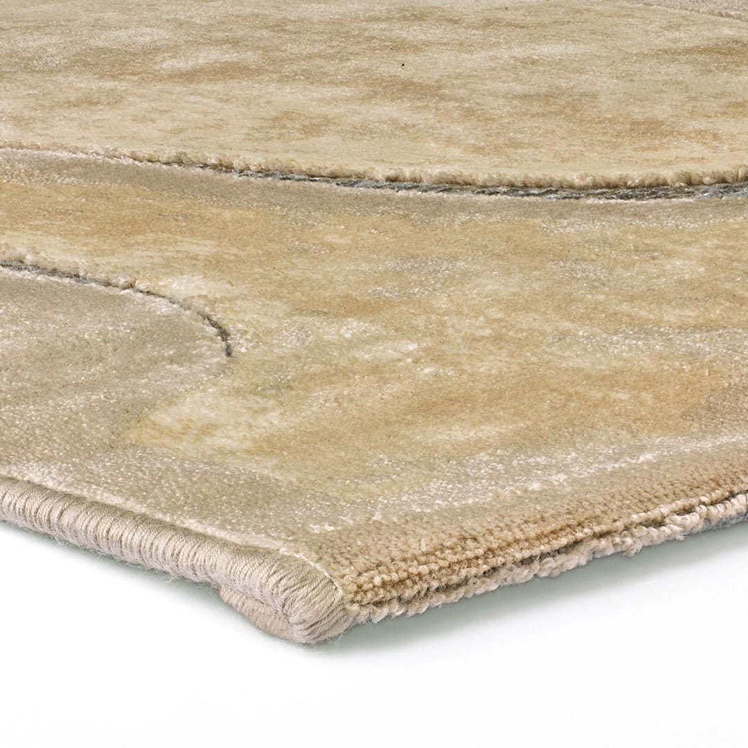 Gros plan sur le motif curviligne 3D sable et terre du tapis Gabrielle